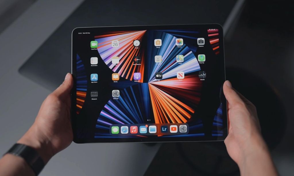 Eine Nahaufnahme von Händen, die ein iPad halten und den Startbildschirm zeigen
